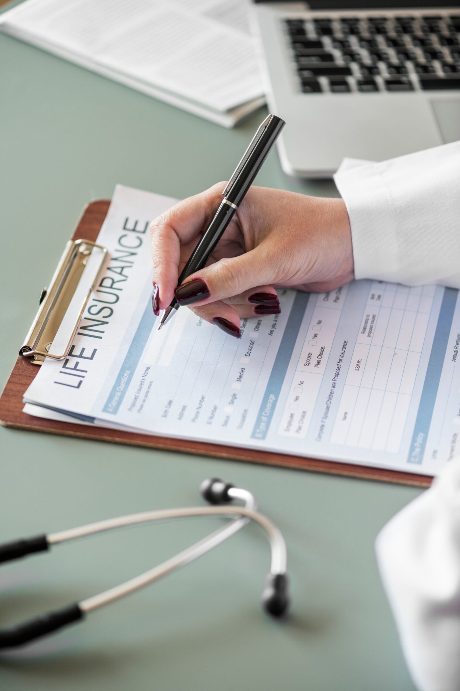 Closeup doctor filling life insurance form